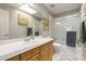 Bright bathroom featuring a large mirror, a shower with glass doors, and ample lighting at 1202 E Desert Broom Way, Phoenix, AZ 85048