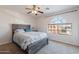 Comfortable bedroom featuring a rustic wood bed frame, carpet, and a uniquely shaped window at 12925 W Llano Dr, Litchfield Park, AZ 85340