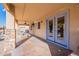 Relaxing covered patio featuring ceiling fan, stone accents, and view of the lush backyard at 12925 W Llano Dr, Litchfield Park, AZ 85340