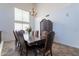 Dining room with an ornate dark wood table, leather chairs, chandelier, and large windows for natural light at 12925 W Llano Dr, Litchfield Park, AZ 85340