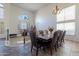 Elegant dining room featuring a dark wood table, leather chairs, chandelier, and large windows for ample light at 12925 W Llano Dr, Litchfield Park, AZ 85340