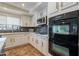 Kitchen features white cabinets, stainless appliances, gray subway tile and light countertops at 12925 W Llano Dr, Litchfield Park, AZ 85340