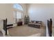 Comfortable living room featuring high ceilings, an arched window, and a cozy gray sectional sofa at 12925 W Llano Dr, Litchfield Park, AZ 85340