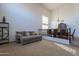 Bright living room featuring a plush gray sofa, high ceilings, and adjacent dining area with elegant furniture at 12925 W Llano Dr, Litchfield Park, AZ 85340