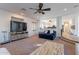 Open living area with large TV, ceiling fan, and view into the kitchen at 12925 W Llano Dr, Litchfield Park, AZ 85340