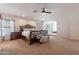 Large primary bedroom featuring a ceiling fan, natural light, and a cozy sitting area at 12925 W Llano Dr, Litchfield Park, AZ 85340