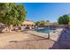 Relaxing pool with a built-in grill area and lush landscaping for outdoor enjoyment at 12925 W Llano Dr, Litchfield Park, AZ 85340