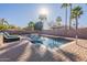 Bright backyard with a clear pool, stone surround, and desert landscaping at 12925 W Llano Dr, Litchfield Park, AZ 85340