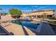 Private backyard pool area with lounge seating, desert landscape, and exterior kitchen at 12925 W Llano Dr, Litchfield Park, AZ 85340