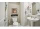 Charming powder room with a pedestal sink, round mirror, and decorative artwork at 12956 W Eagle Ridge Ln, Peoria, AZ 85383