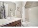 Bright bathroom featuring a wood vanity, framed mirror, and shower over a white tub at 12956 W Eagle Ridge Ln, Peoria, AZ 85383