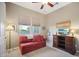 Cozy bedroom featuring a red couch, TV, and a comfortable atmosphere at 12956 W Eagle Ridge Ln, Peoria, AZ 85383