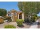 Charming desert home with neutral stucco, desert landscaping, and covered entry near colorful trees at 12956 W Eagle Ridge Ln, Peoria, AZ 85383