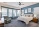 Tranquil bedroom featuring soft blue walls, a plush chair, and plenty of natural light from large windows at 13054 W Big Oak St, Peoria, AZ 85383