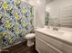 Well-maintained bathroom with a colorful shower curtain, a neutral-colored vanity, and toilet at 13487 W Buckskin Trl, Peoria, AZ 85383