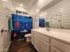 Bathroom with a shower curtain featuring underwater animals, white cabinets, and brown floors at 13487 W Buckskin Trl, Peoria, AZ 85383