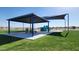 Community playground featuring covered picnic tables, a climbing rock, and grassy surroundings at 13487 W Buckskin Trl, Peoria, AZ 85383