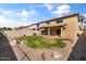 View of the lush backyard, featuring a lawn, rock landscaping, and a covered patio area at 14309 W Weldon Ave, Goodyear, AZ 85395