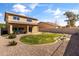 Large backyard with rock landscaping, green grass, a covered patio, and a block fence at 14309 W Weldon Ave, Goodyear, AZ 85395