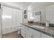 Neutral bathroom with wood-look floors, white cabinets, granite countertops, and a shower with curtain at 14309 W Weldon Ave, Goodyear, AZ 85395