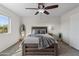 Bedroom features neutral carpet, ceiling fan, and comfortable bedding at 14309 W Weldon Ave, Goodyear, AZ 85395