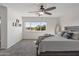 Bedroom features neutral carpet, ceiling fan, and comfortable bedding at 14309 W Weldon Ave, Goodyear, AZ 85395