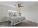 Bright bedroom with neutral carpet, ceiling fan, and comfortable bedding at 14309 W Weldon Ave, Goodyear, AZ 85395