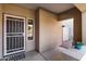 A view of the front porch featuring a security door, tile and desert landscaping at 14309 W Weldon Ave, Goodyear, AZ 85395