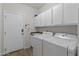 Well-equipped laundry room with modern washer, dryer, and storage cabinets at 14309 W Weldon Ave, Goodyear, AZ 85395