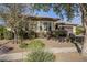 Beautifully landscaped front yard with plants and a mature tree enhancing this home's natural charm at 14762 W Georgia Dr, Surprise, AZ 85379