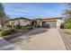 Charming single-story home featuring a two-car garage, desert landscaping, and a paver driveway at 14762 W Georgia Dr, Surprise, AZ 85379