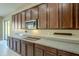 A modern kitchen with a stainless steel microwave, dark cabinets, and granite countertops at 14762 W Georgia Dr, Surprise, AZ 85379