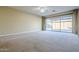 Bright living room with plush carpet, neutral walls, and sliding glass doors to the landscaped backyard at 14762 W Georgia Dr, Surprise, AZ 85379