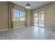 A bright living room with tile floors, neutral walls, and a sliding glass door to the backyard at 14762 W Georgia Dr, Surprise, AZ 85379