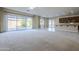 Bright living room with plush carpet, neutral walls, and sliding glass doors to the landscaped backyard at 14762 W Georgia Dr, Surprise, AZ 85379