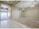 Spacious living room featuring neutral carpet, a large window, and decorative chandeliers at 14762 W Georgia Dr, Surprise, AZ 85379