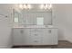 Bathroom featuring double sinks with a large mirror and white cabinets with dark hardware at 1588 N Pueblo Dr, Apache Junction, AZ 85120