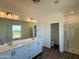 Bright bathroom featuring a double vanity, modern lighting fixtures, and a glass-enclosed shower at 1588 N Pueblo Dr, Apache Junction, AZ 85120