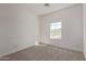 A carpeted bedroom filled with natural light from a window offering neighborhood views at 1588 N Pueblo Dr, Apache Junction, AZ 85120