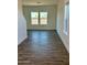 Bright living room featuring elegant wood-look tile flooring and ample natural light from large windows at 1588 N Pueblo Dr, Apache Junction, AZ 85120