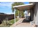 Backyard featuring a covered patio, brick pavers, green lawn, and privacy fence, perfect for outdoor living at 17016 N 66Th Ter, Glendale, AZ 85308