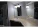 Bathroom featuring a vanity with mirrors, tile backsplash, and ample counter space at 17016 N 66Th Ter, Glendale, AZ 85308