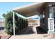 View of exterior carport area with manicured shrubbery and sidewalks at 17016 N 66Th Ter, Glendale, AZ 85308