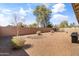 Spacious gravel backyard with a grill, perimeter block wall, and privacy landscaping at 18382 N Arbor Dr, Maricopa, AZ 85138