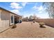 Large gravel backyard with block fence, grill, patio, and some young trees at 18382 N Arbor Dr, Maricopa, AZ 85138