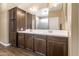 Bathroom with double vanity, dark wood cabinets, and a large mirror at 18382 N Arbor Dr, Maricopa, AZ 85138