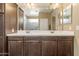 Bathroom with double vanity, dark wood cabinets, and a large mirror at 18382 N Arbor Dr, Maricopa, AZ 85138