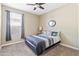 Neutral toned bedroom with carpet, ceiling fan, window and a decorative mirror at 18382 N Arbor Dr, Maricopa, AZ 85138