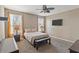 Neutral bedroom with a ceiling fan, carpet flooring, and two large windows for natural light at 18382 N Arbor Dr, Maricopa, AZ 85138