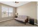 Simple bedroom featuring carpet, a ceiling fan and a futon under a bright window at 18382 N Arbor Dr, Maricopa, AZ 85138